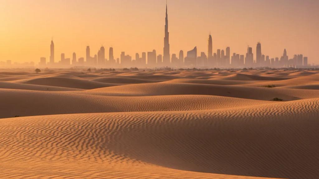 UK traveler by the Dubai skyline at dusk checking a phone showing a connected mobile signal