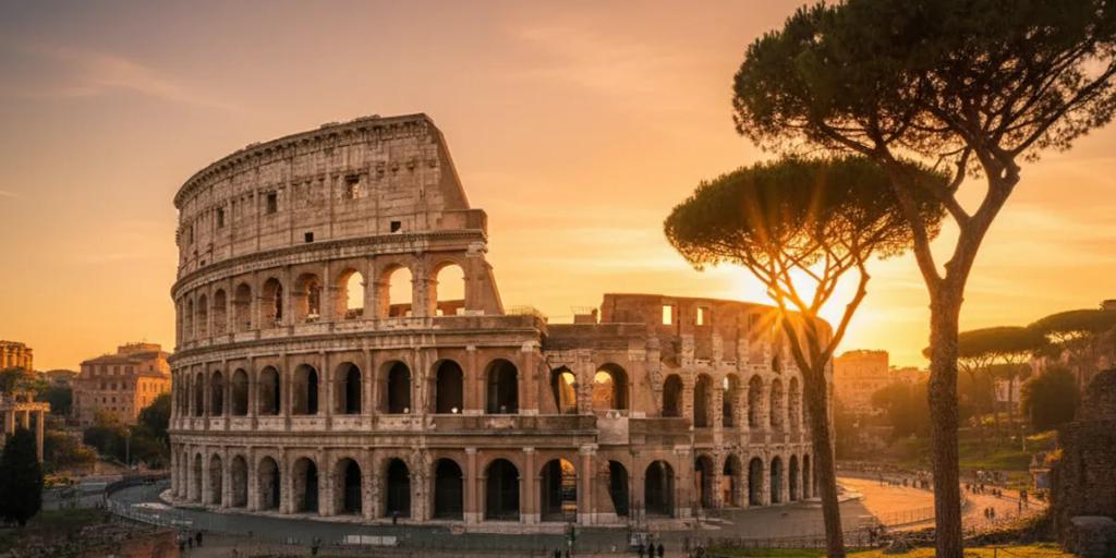 Rome rooftops at golden hour with the Colosseum rising above the terracotta skyline