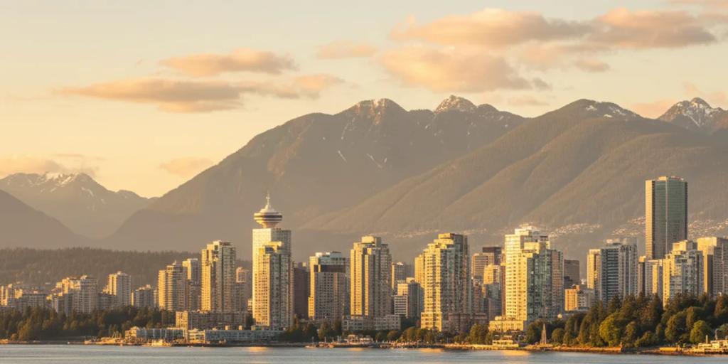 Vancouver's glass skyline with seaplanes taxiing on Coal Harbour and the North Shore mountains rising behind