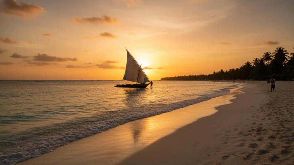 Traditional dhow sailing off a Zanzibar beach at sunset